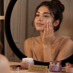 Femme applique crème de nuit peau grasse devant miroir