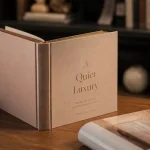 Livre relié sur bureau en bois, tranche dorée, jaquette à côté